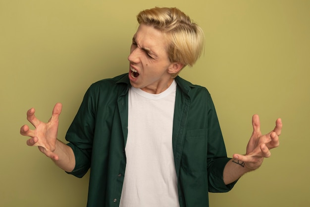 Photo gratuite en colère, les yeux fermés, jeune mec blond portant un t-shirt vert répandre les mains