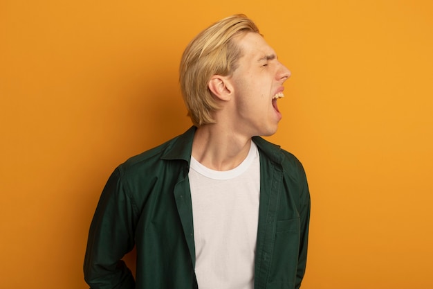 En colère avec les yeux fermés jeune mec blond portant un t-shirt vert