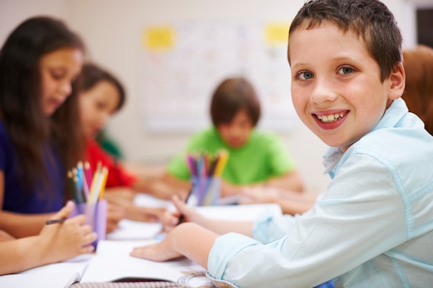 Écolier faisant ses devoirs dans la salle de classe