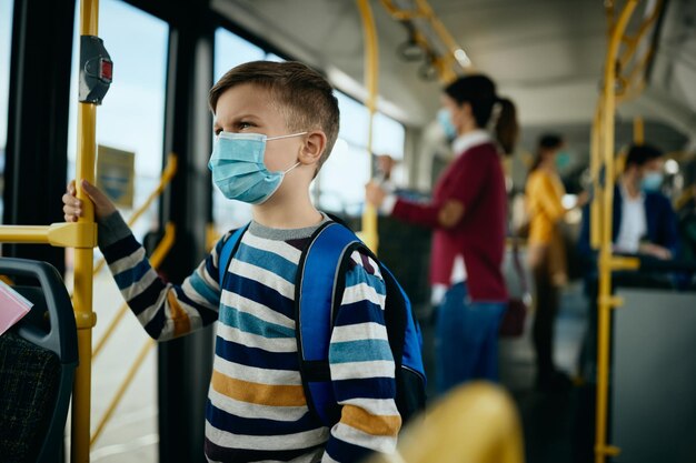 Écolier portant un masque protecteur lors de ses déplacements en bus public