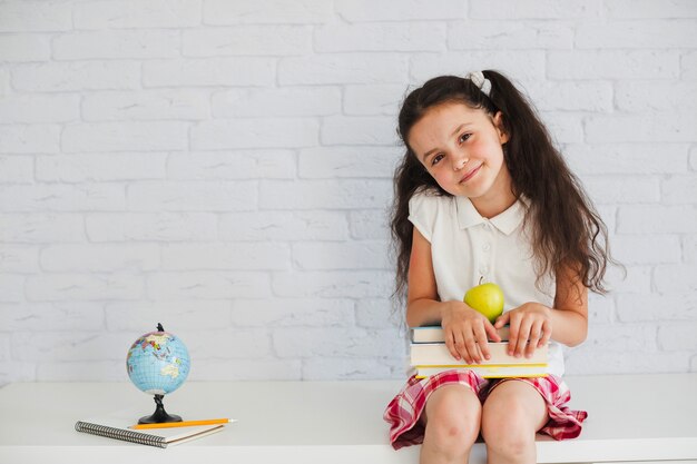 Écolière assise et souriante