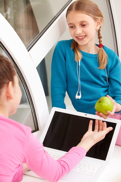 Écolière donnant une pomme à son camarade de classe