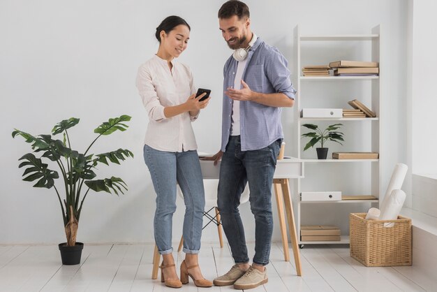 Collaborateurs au bureau à l'aide de téléphone