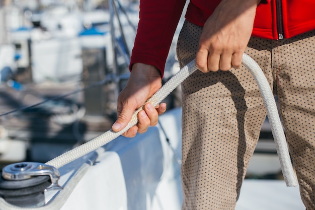 Photo gratuite collants professionnels de marin ou de plaisancier et câble de tension ou câble métallique sur treuil mécanique sur voilier ou yacht