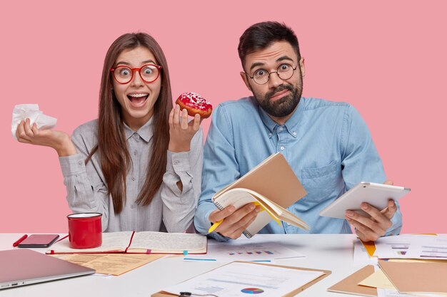 Collègues assis au bureau avec des documents et des gadgets