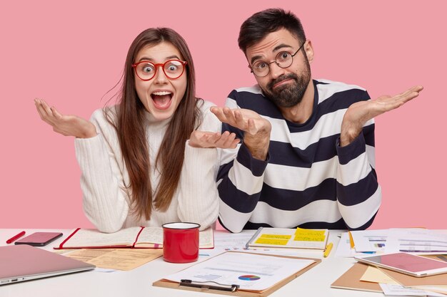 Collègues assis au bureau avec des documents et des gadgets