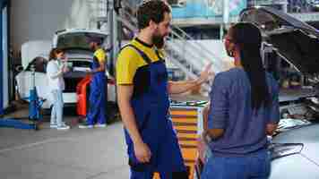 Photo gratuite des collègues au garage réparent la voiture des clients.