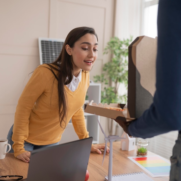 Collègues au travail, manger de la pizza