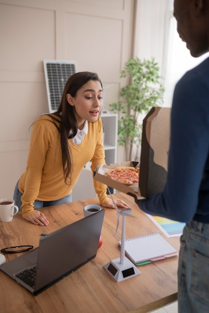 Collègues au travail, manger de la pizza