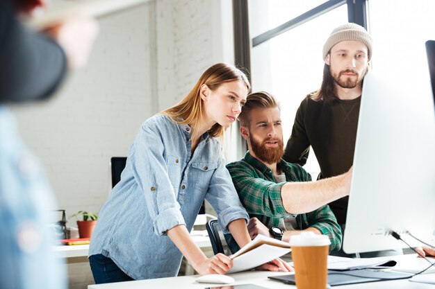 Collègues concentrés au bureau à l'aide d'un ordinateur