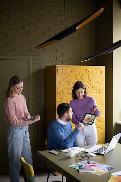 Photo gratuite collègues à coup moyen travaillant au bureau