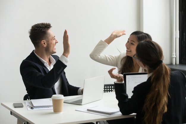 Collègues donnant la haute cinq célébrer le succès partagé