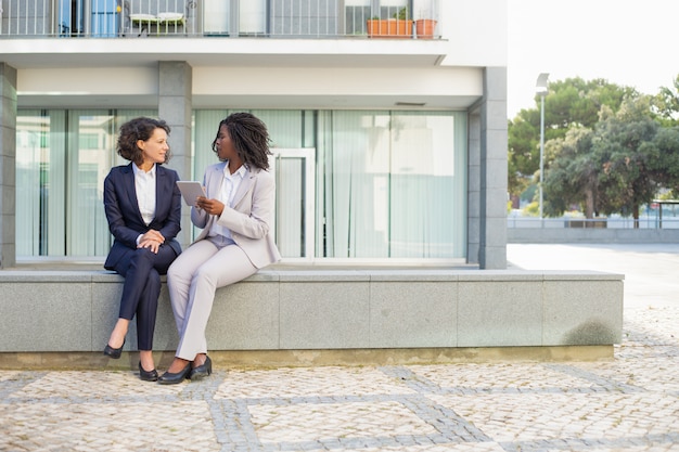 Collègues féminines avec tablette en plein air