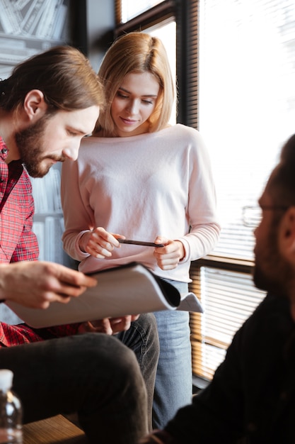 Collègues gais assis dans le bureau et le coworking