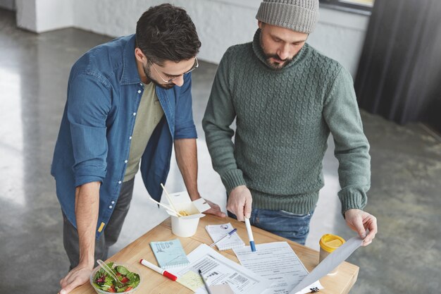 Collègues masculins au bureau avec déjeuner