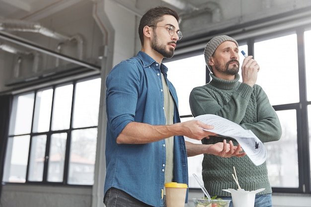 Collègues masculins au bureau avec déjeuner