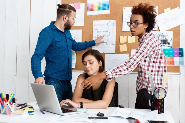 Des collègues parlent, discutent de dessins, de nouvelles idées au bureau