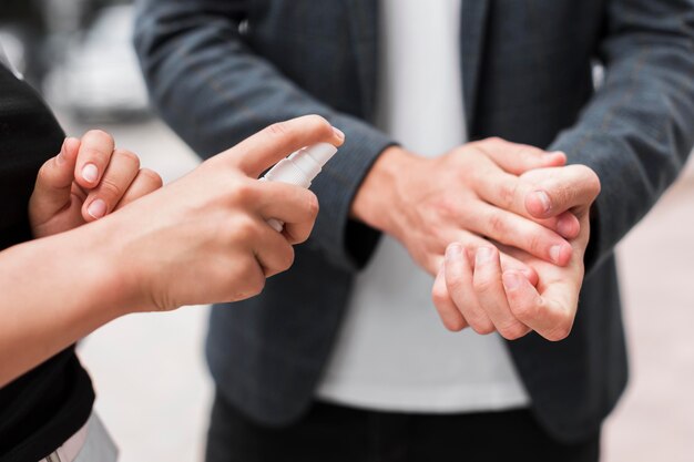 Des collègues se désinfectent les mains à l'extérieur pendant une pandémie