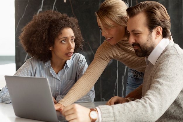 Photo gratuite collègues souriants de plan moyen au travail