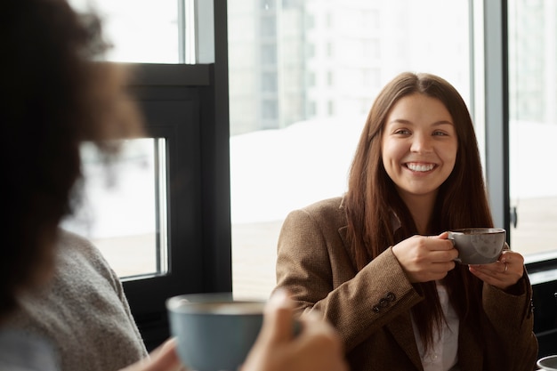 Collègues souriants avec des tasses à café au travail