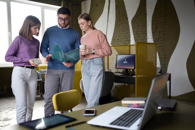 Photo gratuite collègues de taille moyenne lisant ensemble