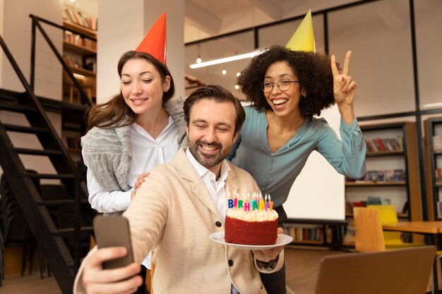 Collègues de taille moyenne prenant un selfie ensemble