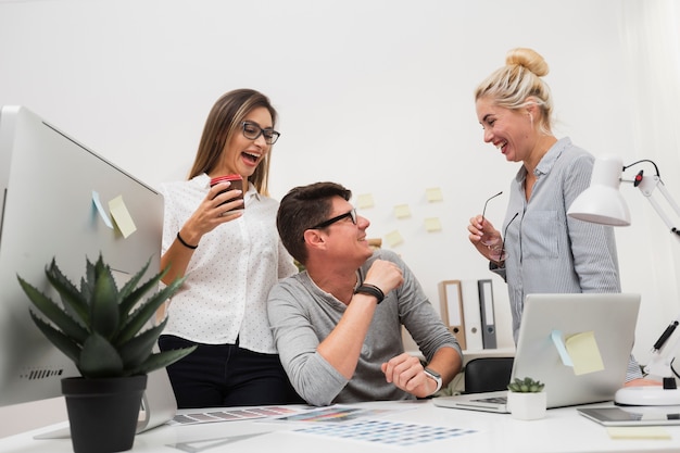 Des collègues de travail souriant et se regardant