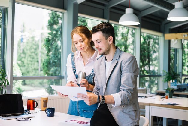 Collègues vérifiant les plans au bureau