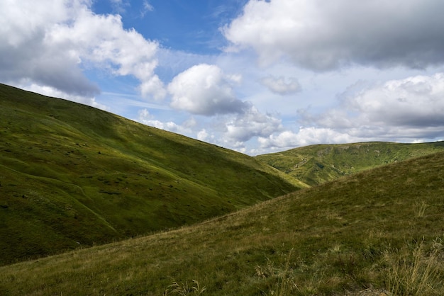 Des collines herbeuses sous un ciel bleu nuageux un jour d'automne nuageux