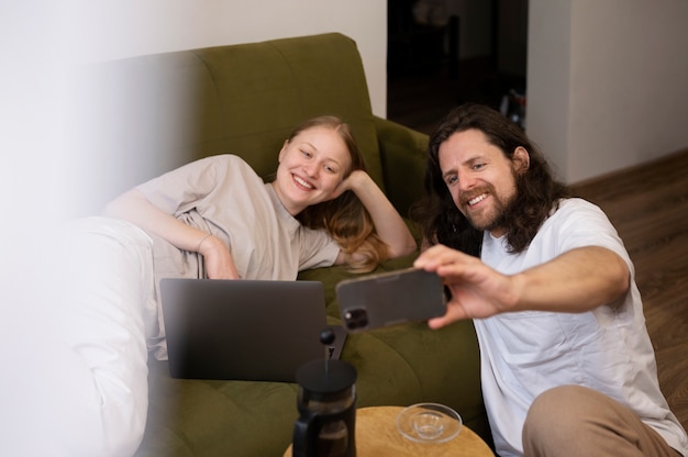 Colocataires souriants à coup moyen prenant selfie