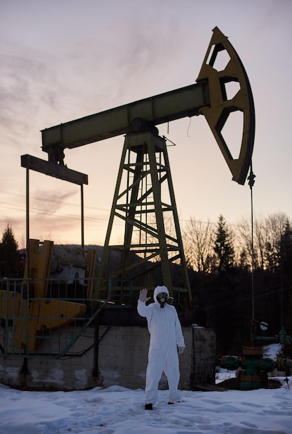 Écologiste debout près de la prise de pompe de puits de pétrole