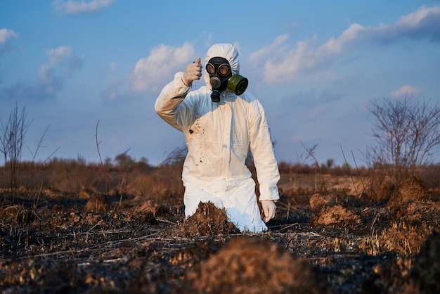 Écologiste examinant le sol dans le champ après un incendie