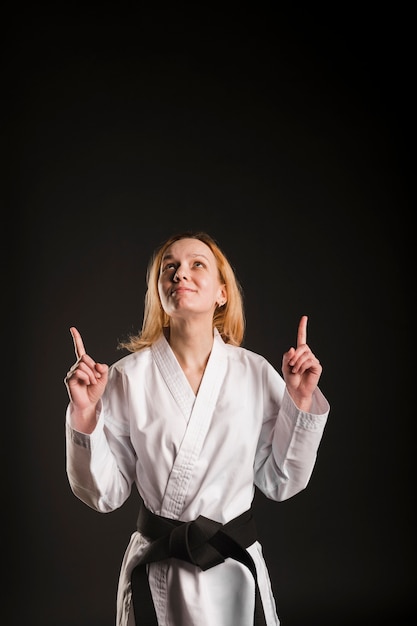 Photo gratuite combattant féminin pointant vers le haut plan moyen