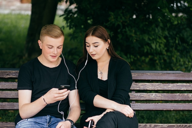 compagnie de jeunes amis avec smartphones marchant dans la ville