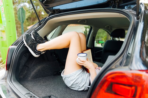 Compartiment à bagages ouvert de la machine avec les pieds des femmes