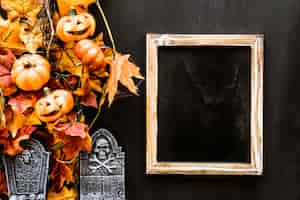 Photo gratuite composition d'ardoise d'halloween avec feuilles et pierre tombale