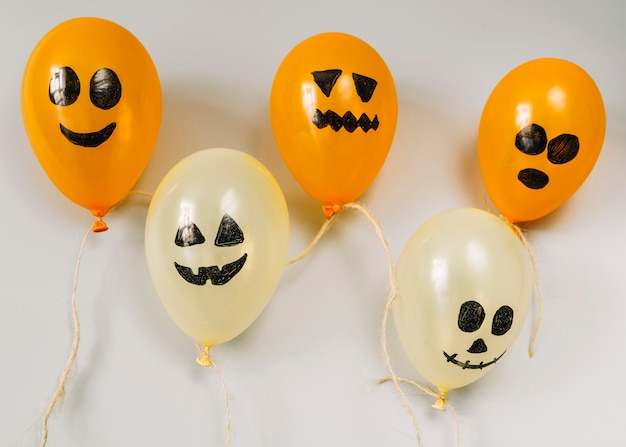 Composition avec des ballons orange et blanc avec des visages effrayants