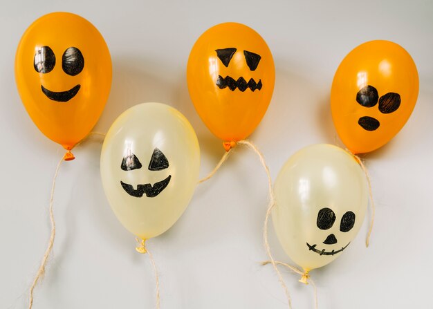 Composition avec des ballons orange et blanc avec des visages effrayants