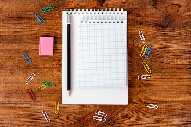 Composition avec cahier coloré de page blanche de cahier, marqueur et maquette de stylo retour au concept de l'école