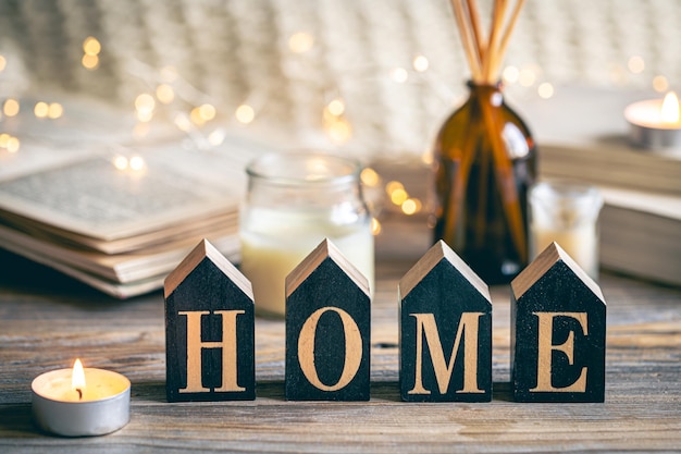 Photo gratuite composition confortable avec une maison en bois et des bougies sur un fond flou