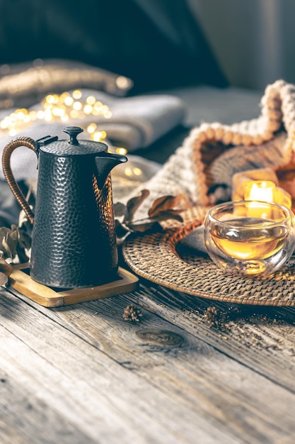 Photo gratuite composition confortable pour la maison avec une tasse de thé avec des bougies à thé et un élément tricoté