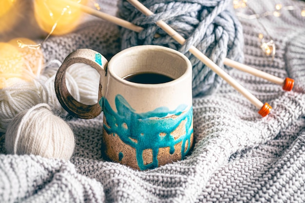 Photo gratuite composition confortable avec une tasse de fils de café et un élément tricoté