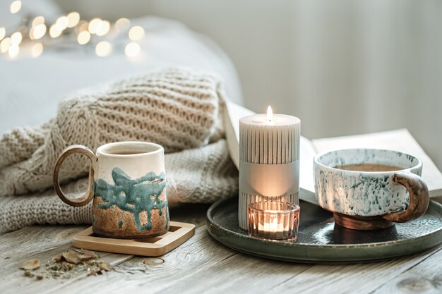 Composition confortable avec des tasses et des bougies en céramique