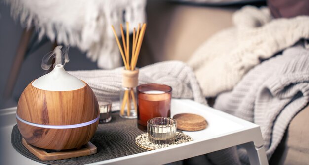 Une composition cosy avec un diffuseur d'arômes et des bougies dans un intérieur de maison