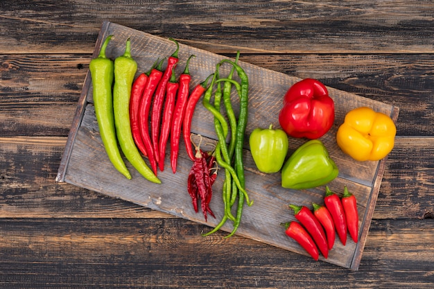 composition décorative avec piment et poivrons vue de dessus sur une planche à découper en bois sur bois