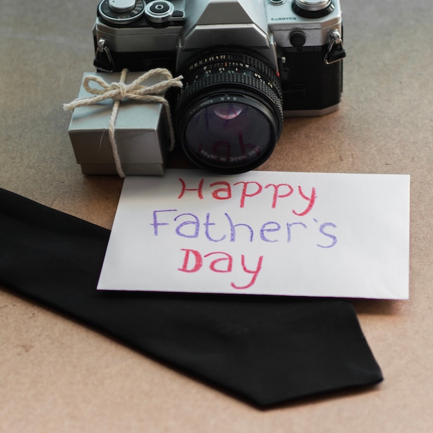 Photo gratuite composition du jour du père avec caméra, cravate et enveloppe