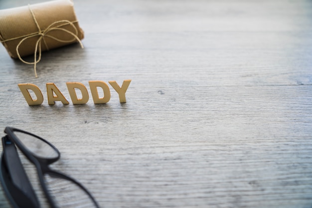 Photo gratuite composition du jour du père avec des lunettes et un cadeau