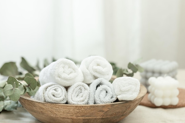 Photo gratuite composition du spa avec des serviettes blanches dans une assiette en bois