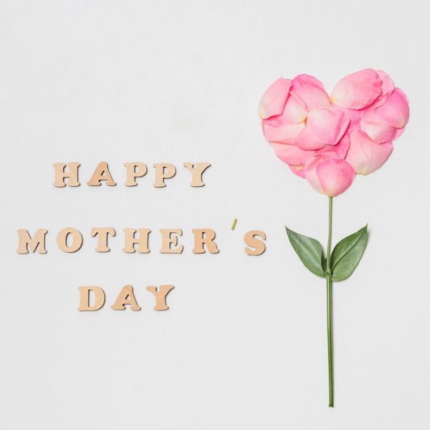 Photo gratuite composition du titre de fête des mères heureux près de la floraison rose en forme de coeur