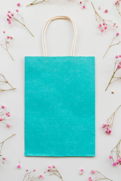 Photo gratuite composition avec emballage bleu et fleurs roses
